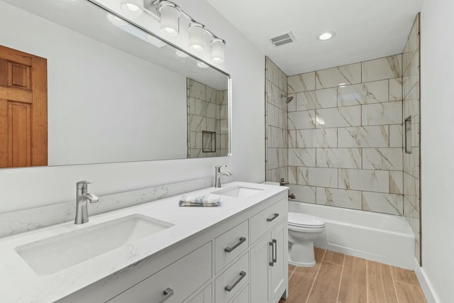 full bath featuring visible vents, a sink, toilet, and wood tiled floor