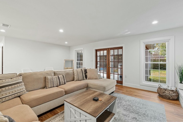 living room featuring recessed lighting, french doors, visible vents, and light wood-style flooring