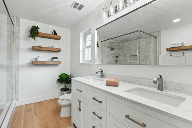 full bath with a stall shower, a sink, and wood finished floors