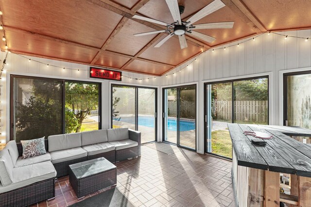 sunroom featuring a ceiling fan and vaulted ceiling