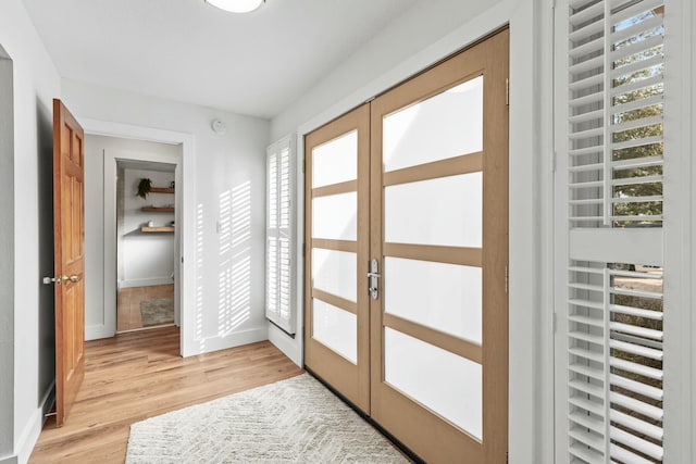 doorway to outside with light wood-style flooring, baseboards, and french doors