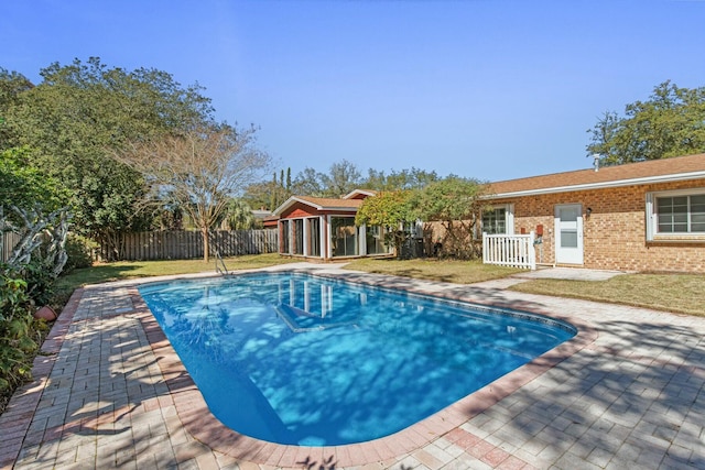 view of pool with a fenced backyard, a lawn, and a patio