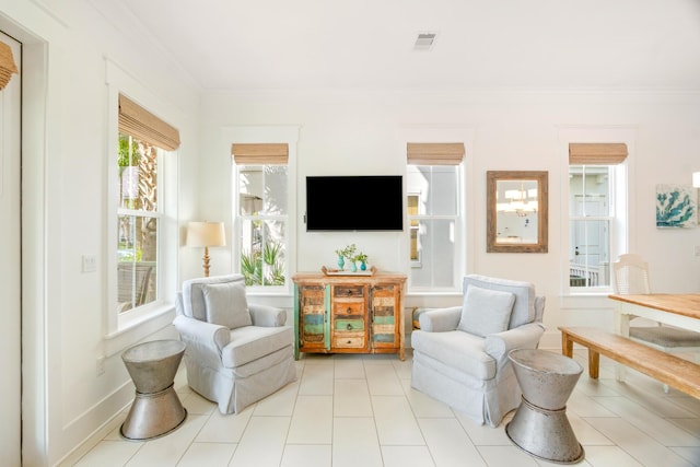 living area with ornamental molding, visible vents, and baseboards