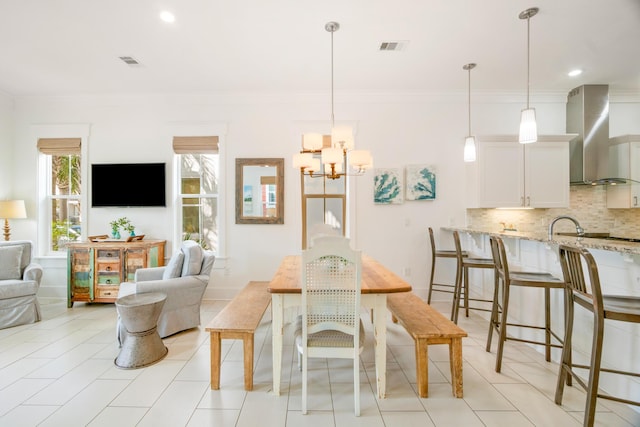 dining space with baseboards, visible vents, and crown molding