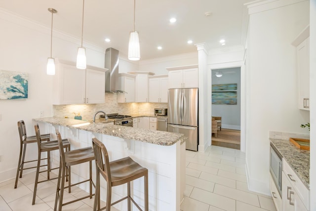 kitchen featuring crown molding, stainless steel appliances, tasteful backsplash, a peninsula, and wall chimney exhaust hood