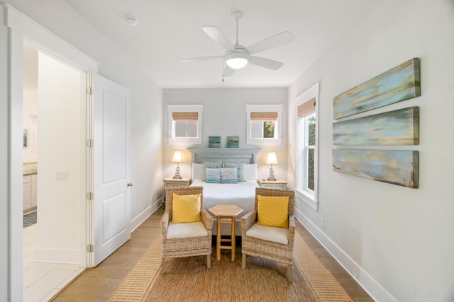 sitting room featuring ceiling fan, wood finished floors, and baseboards