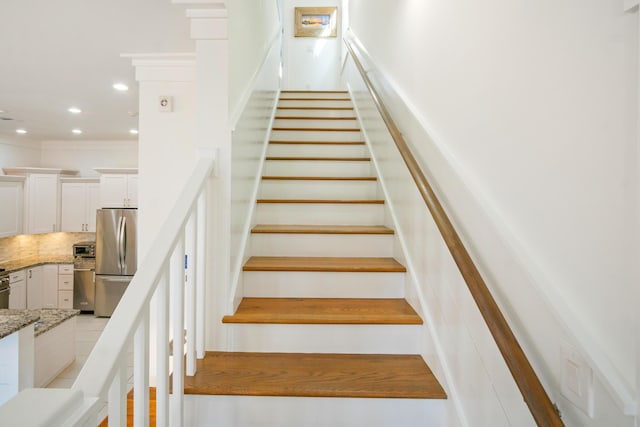 stairway featuring crown molding and recessed lighting