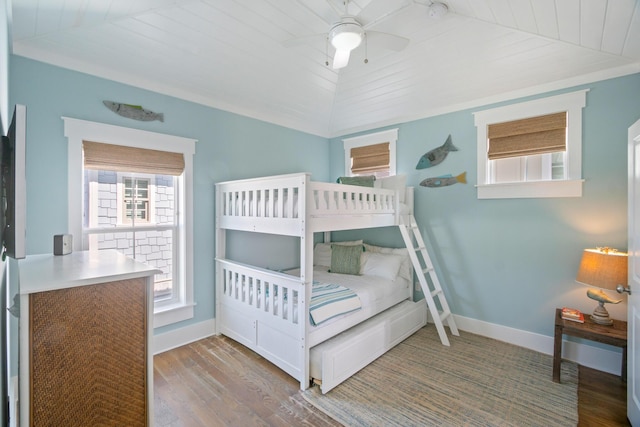 bedroom with wood ceiling, vaulted ceiling, baseboards, and wood finished floors