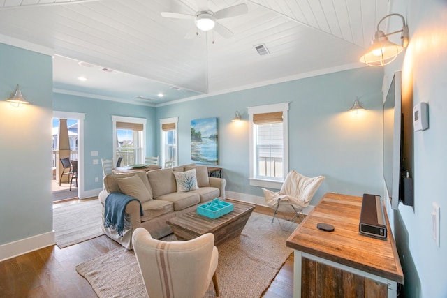 living room with crown molding, visible vents, a ceiling fan, wood finished floors, and baseboards