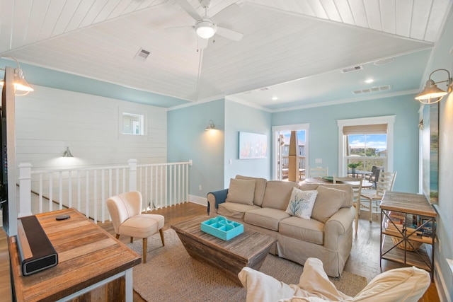 living room with visible vents, vaulted ceiling, and wood finished floors