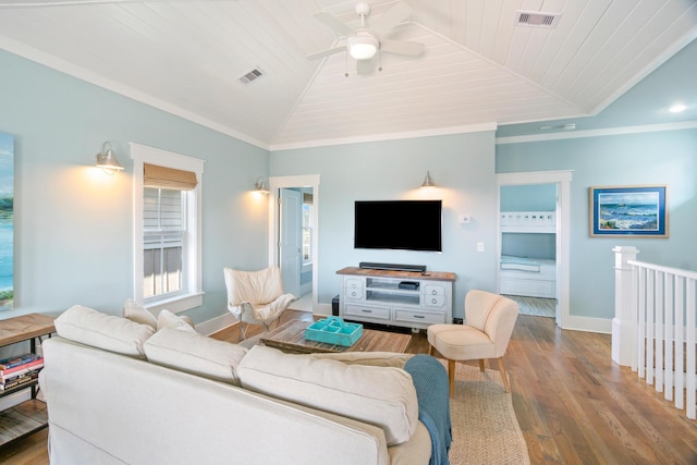 living area featuring ornamental molding, visible vents, vaulted ceiling, and wood finished floors