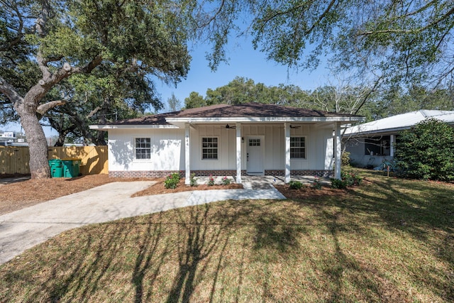 ranch-style home featuring covered porch and a front yard