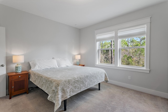 bedroom featuring light colored carpet and baseboards