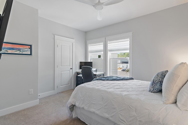 bedroom with a ceiling fan, light carpet, and baseboards