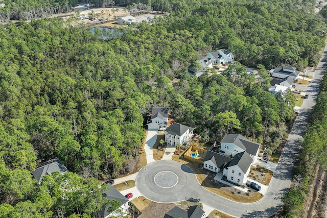 drone / aerial view featuring a forest view and a residential view