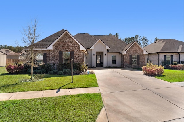 view of front of house with board and batten siding, brick siding, and a front lawn