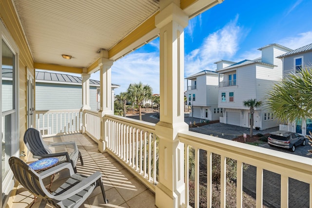 balcony featuring a residential view, a sunroom, and covered porch