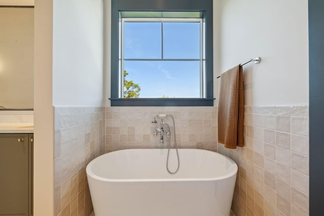 215 Buddy St, Santa Rosa Beach, FL 32459 - bathroom with tile walls, a freestanding bath, vanity, and a wainscoted wall