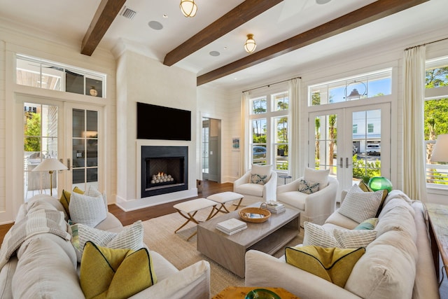 215 Buddy St, Santa Rosa Beach, FL 32459 - living area with french doors, beam ceiling, plenty of natural light, a warm lit fireplace, and wood finished floors