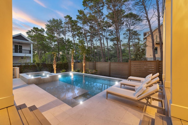 215 Buddy St, Santa Rosa Beach, FL 32459 - pool at dusk featuring a fenced backyard, a pool with connected hot tub, and a patio