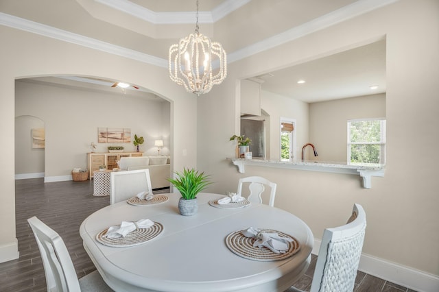 dining room with arched walkways, dark wood-style flooring, a chandelier, and baseboards