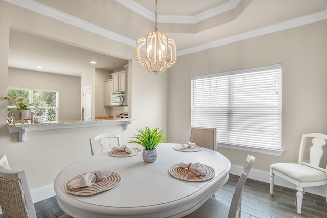 dining area with ornamental molding, dark wood finished floors, baseboards, and an inviting chandelier