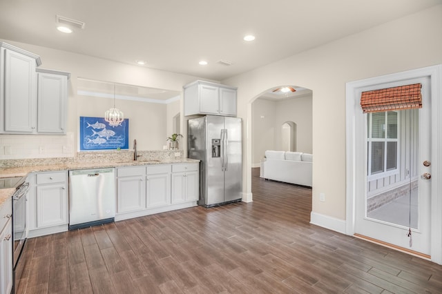 kitchen with stainless steel appliances, dark wood finished floors, white cabinets, and a sink