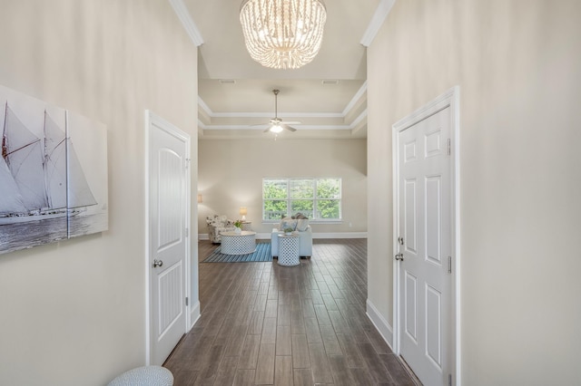 corridor featuring baseboards, ornamental molding, a raised ceiling, and dark wood-style flooring