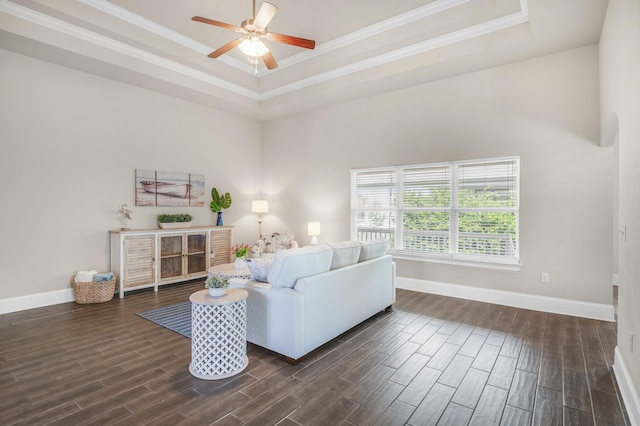 living room with ceiling fan, baseboards, wood tiled floor, a raised ceiling, and crown molding