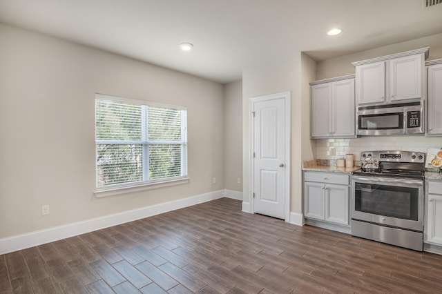 kitchen with baseboards, decorative backsplash, appliances with stainless steel finishes, dark wood-style flooring, and recessed lighting