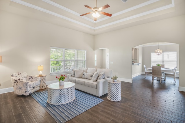 living area with arched walkways, ornamental molding, wood finish floors, and plenty of natural light