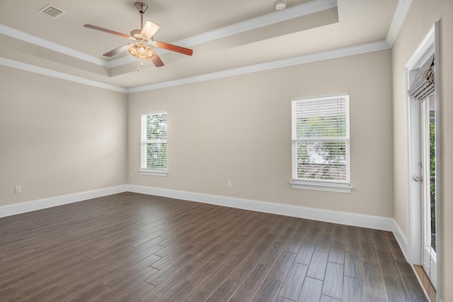 unfurnished room featuring a tray ceiling, dark wood-type flooring, visible vents, and baseboards