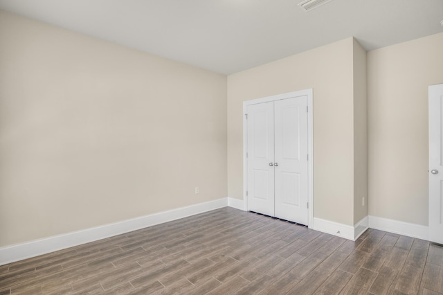 unfurnished bedroom with a closet, baseboards, and wood finished floors