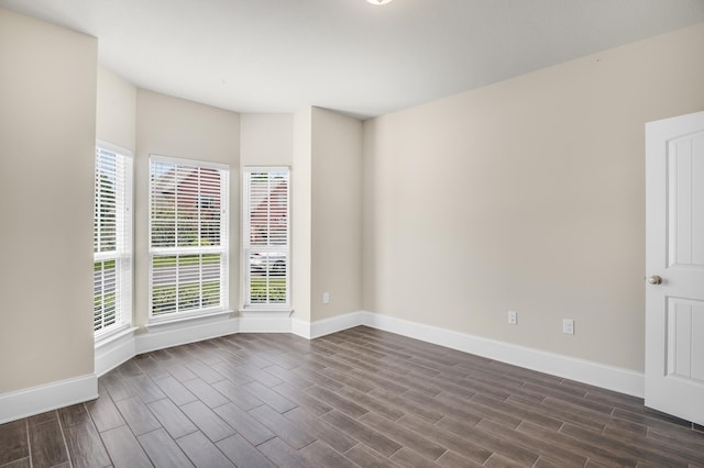 empty room featuring baseboards and wood tiled floor