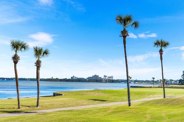 view of property's community featuring a lawn and a water view