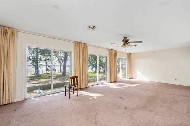 carpeted spare room featuring ceiling fan