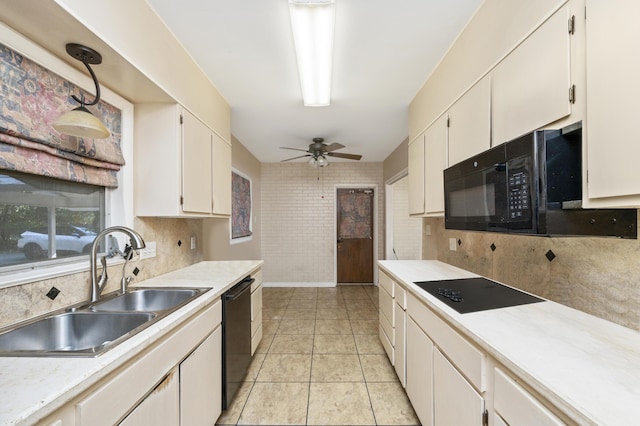 kitchen with sink, light tile patterned floors, black appliances, and white cabinets