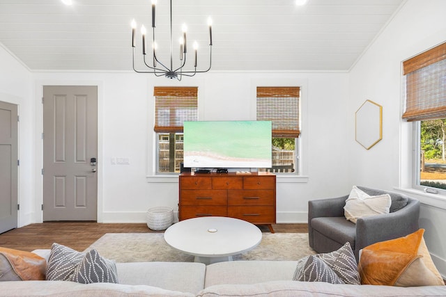 living room featuring a notable chandelier, baseboards, and wood finished floors