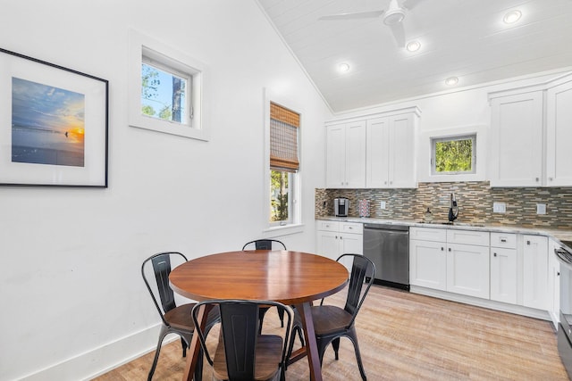 kitchen featuring white cabinets, light wood-type flooring, tasteful backsplash, and stainless steel appliances