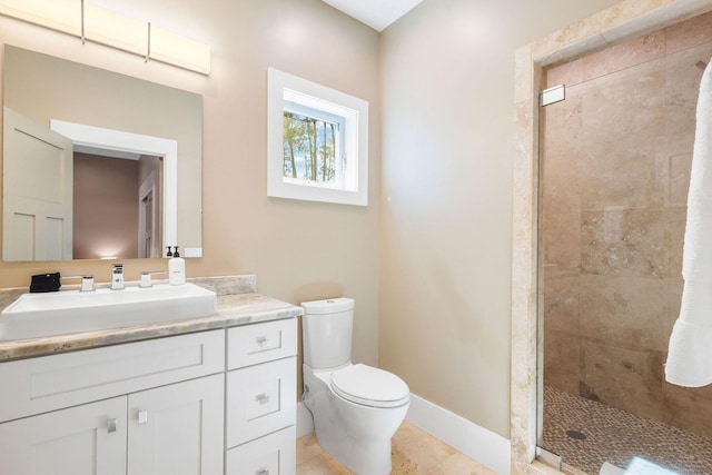 bathroom with baseboards, toilet, tile patterned flooring, vanity, and a shower stall