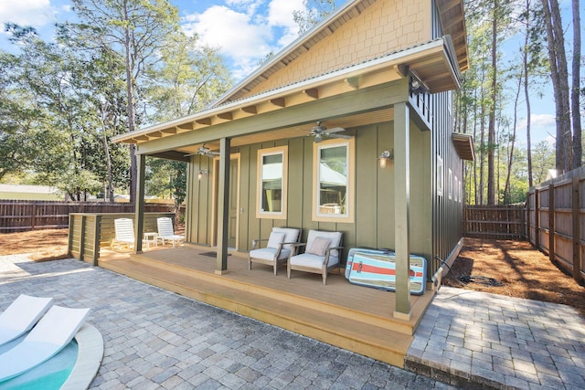 exterior space featuring board and batten siding, a wooden deck, a ceiling fan, and a fenced backyard