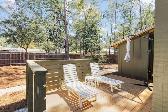 wooden terrace with a fenced backyard