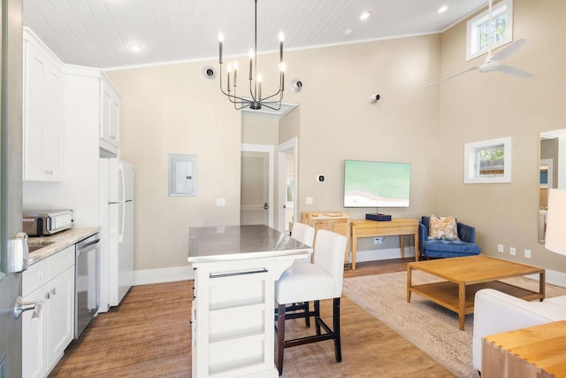 kitchen featuring pendant lighting, stainless steel appliances, a center island, and white cabinets