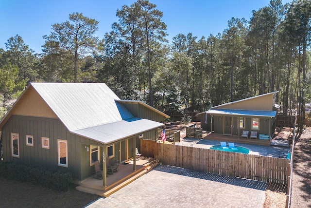 exterior space with a deck, a patio, fence, and a fenced in pool