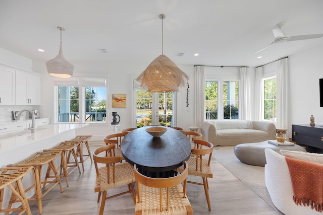 dining space with light wood-type flooring, visible vents, and recessed lighting