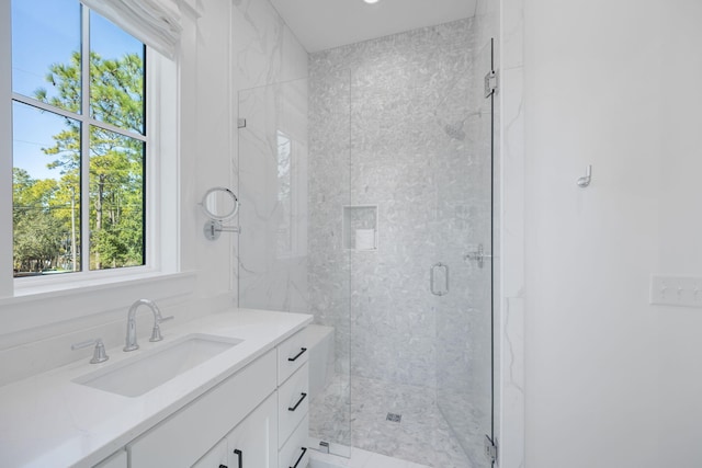 bathroom featuring vanity and a marble finish shower