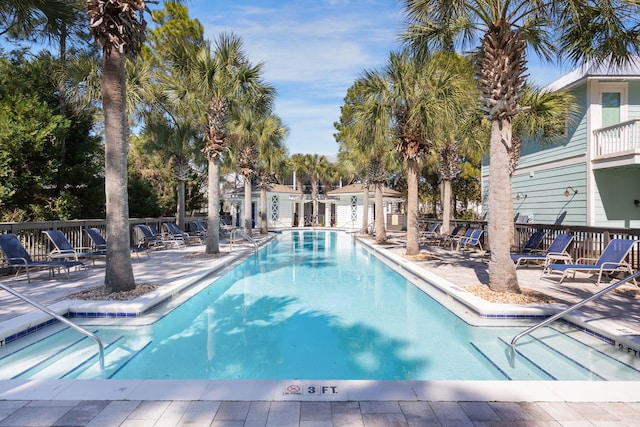 community pool with fence and a patio