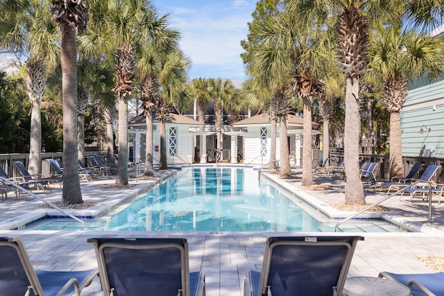 pool with a patio area and fence