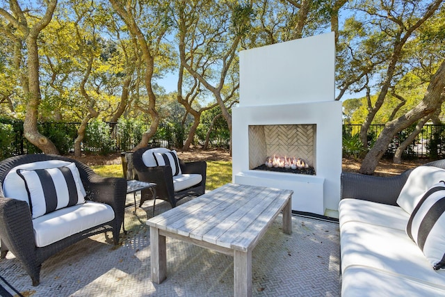 view of patio featuring an outdoor living space with a fireplace and fence