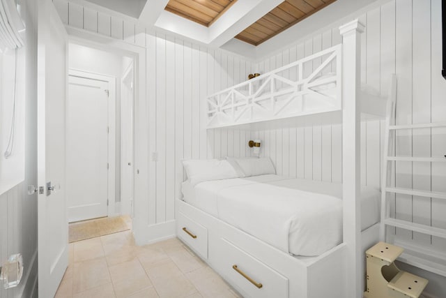 bedroom with light tile patterned floors, wooden walls, and wooden ceiling